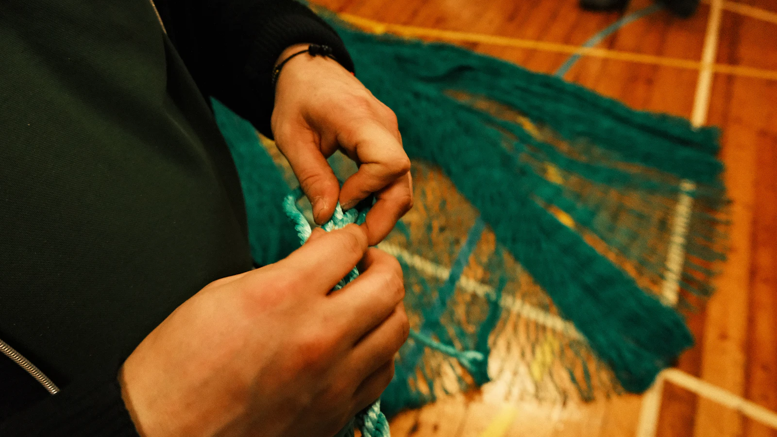 Hands tying a knot in a fishing net